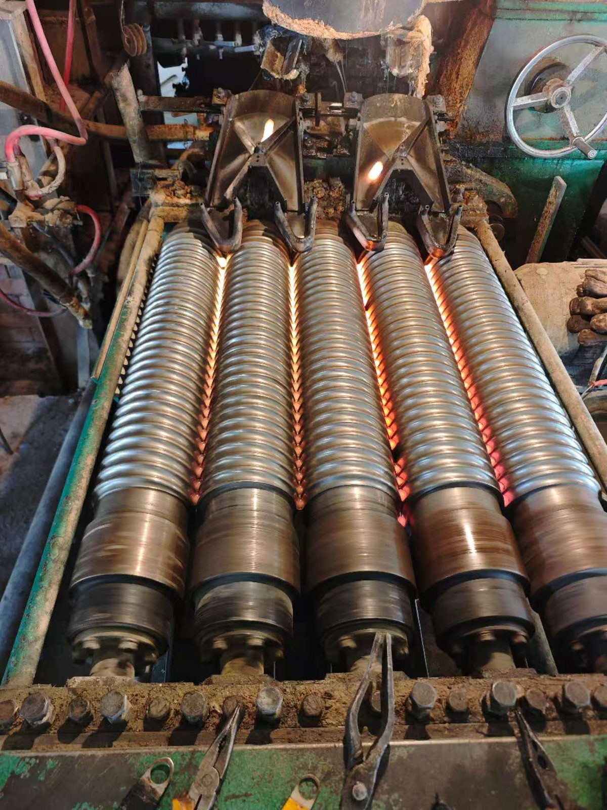 Glass bead rounding line — molten glass drawn through water-cooled rollers at the Jingli plant